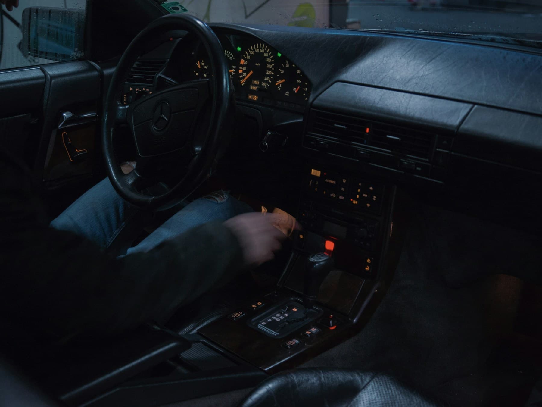 Driver holding the steering wheel of a premium car at night